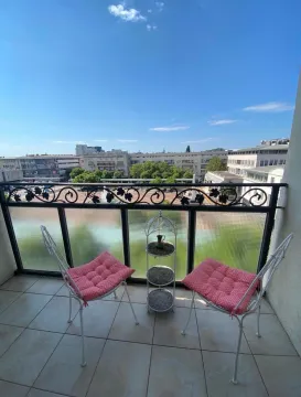 Namješten balkon sa dvije stolice i pogledom na grad. - image 9