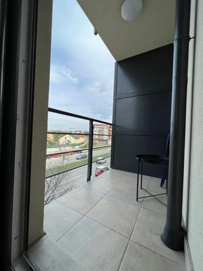 Natkriveni balkon sa pločicama i pogledom na ulicu.