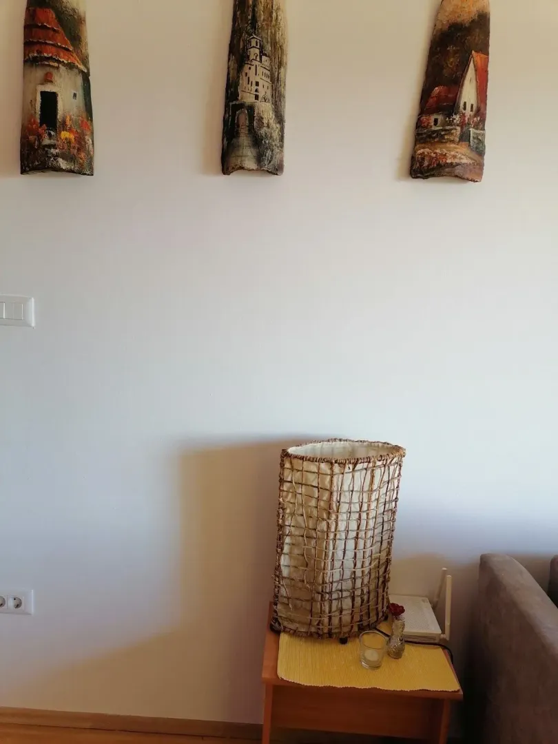 Part of a room with a decorative lamp and paintings on the wall.