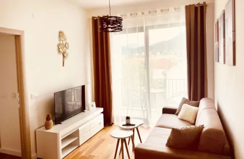Dnevna soba sa garniturom, televizorom i izlazom na terasu. - image 2