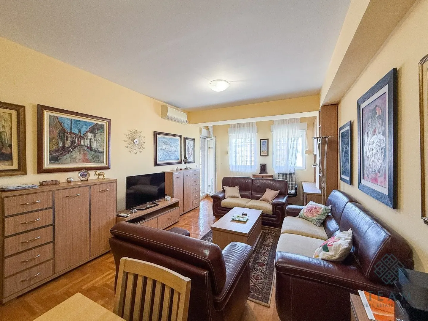 Living room with seating furniture, television, and artwork on the walls.