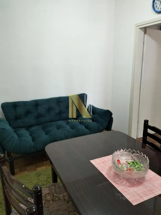 Dnevni boravak sa garniturom i trpezarijskim stolom.