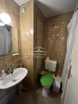 Manje kupatilo obloženo keramičkim pločicama sa umivaonikom i šoljom. - image 9