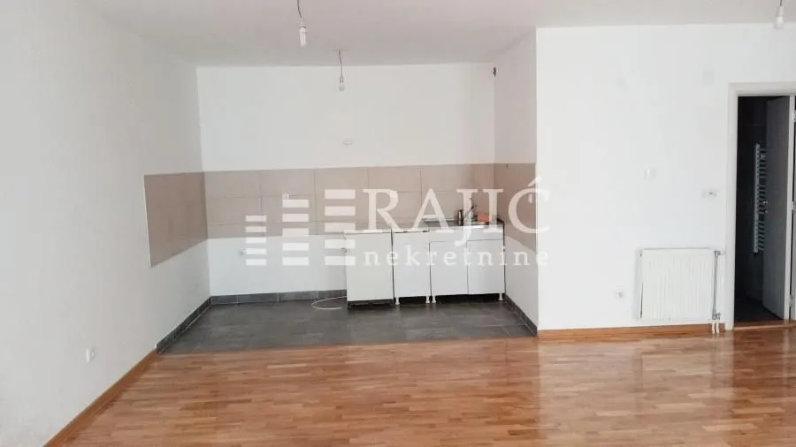 Small kitchen within a bright room with parquet flooring.