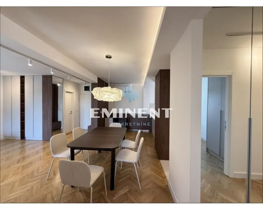 Dining area with a modern table and chairs within the living room.