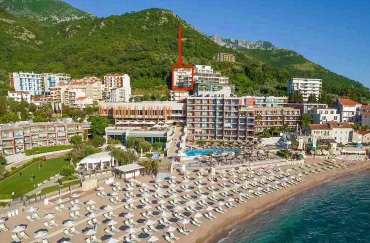 Pogled iz vazduha na hotel i plažu sa označenom lokacijom nekretnine.