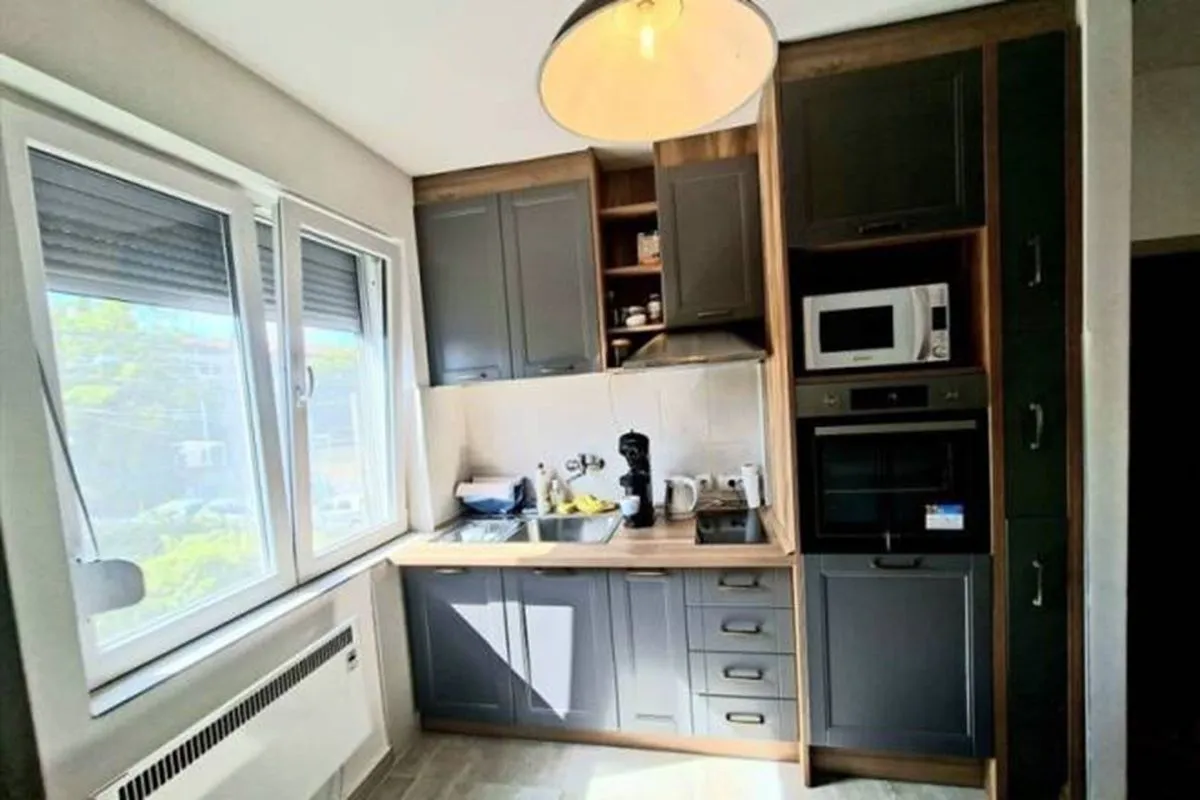 Small kitchen with dark cabinets and a window next to the sink.