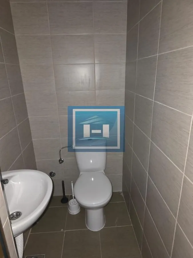 Small tiled bathroom with a toilet and a washbasin.