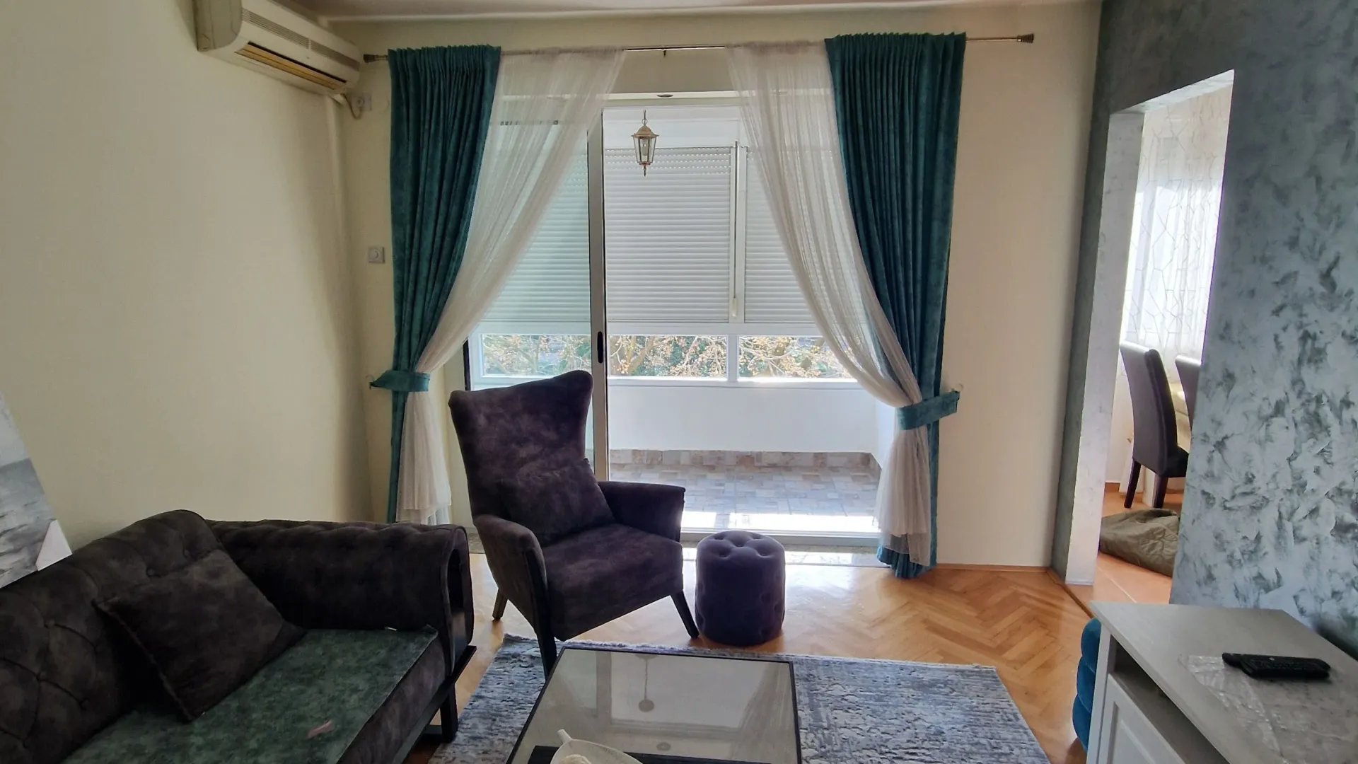 Udobna dnevna soba sa garniturom i dekorativnim lusterom.
