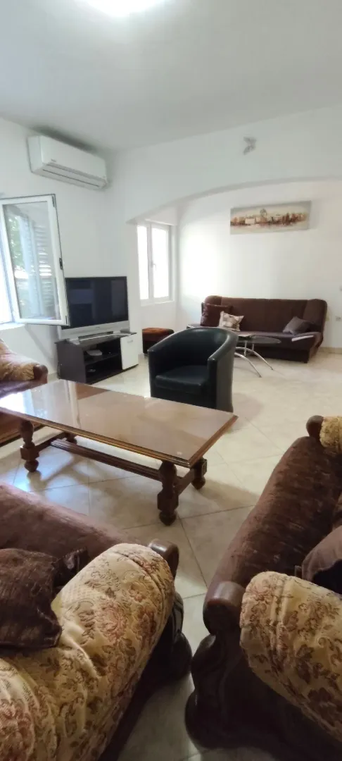 Spacious living room with seating set and television.