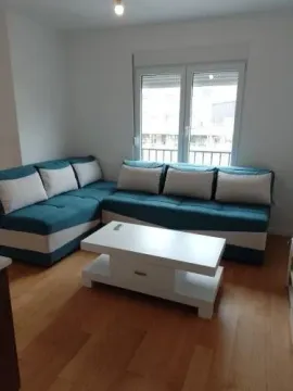 Living room with a blue and white corner sofa and a coffee table. - image 10