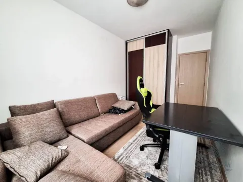 Living room with a sectional sofa, office desk, and wardrobe. - image 8