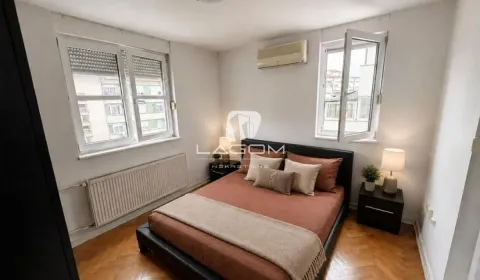 Bedroom with a double bed, bedside tables, and two windows. - image 9