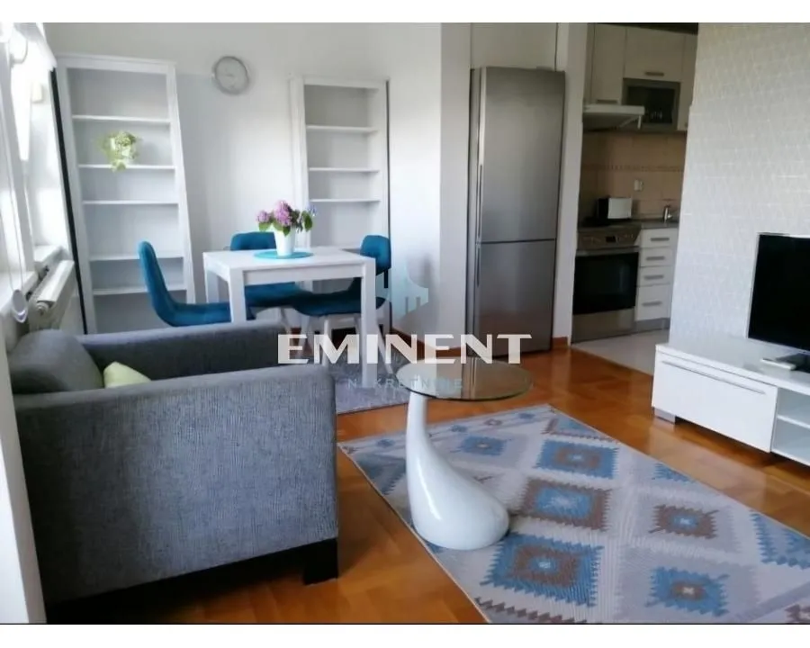 Living room with dining area and part of the kitchen in the background.