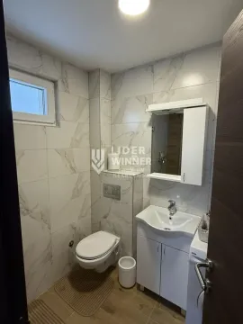 Manje kupatilo obloženo mermernim pločicama sa toaletom, umivaonikom i ormarićem sa ogledalom. - image 7