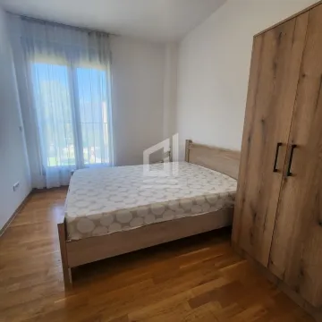 Spavaća soba sa bračnim krevetom, drvenim ormarom i parketom. - image 7