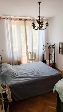 Furnished bedroom with a double bed, window, and chandelier. - image 5