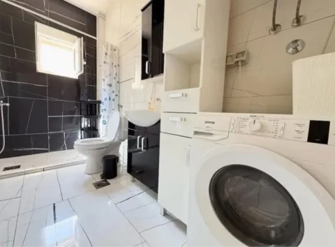 Modernly equipped bathroom with a shower cabin, washbasin, and washing machine. - image 4