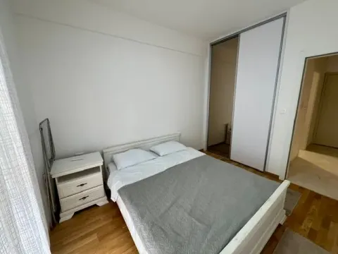 Furnished bedroom with a double bed, nightstand, and built-in wardrobe. - image 7