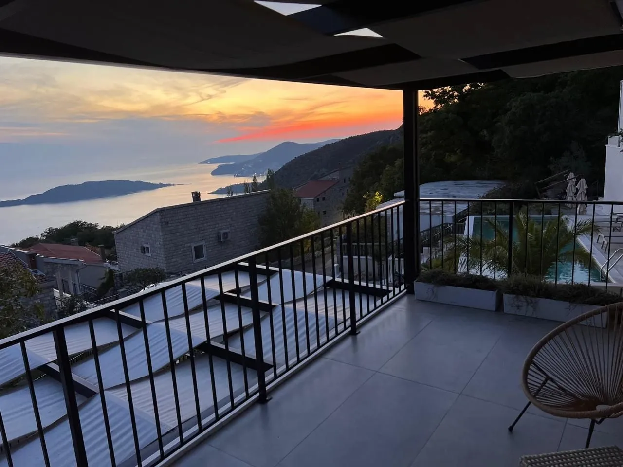 Modern covered terrace with a view of the sea and sunset.