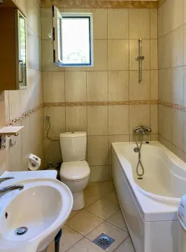 Bathroom equipped with a bathtub, a sink, and a toilet. - image 9