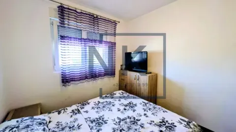 Furnished bedroom with a double bed and a television. - image 10