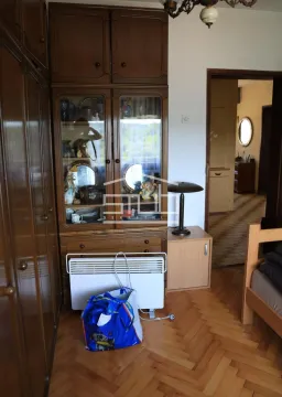 Bedroom with wooden wardrobes, a display cabinet, and parquet flooring. - image 3