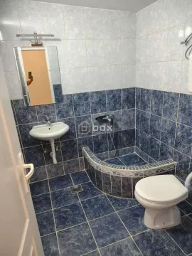 Smaller tiled bathroom with a sink, shower cabin, and toilet. - image 11