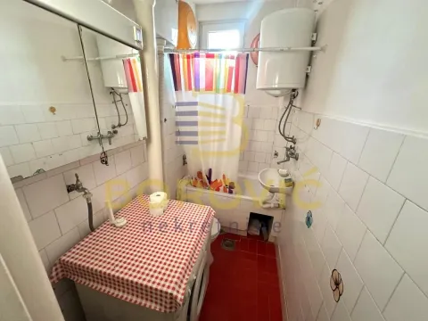 Manje kupatilo sa kadom, umivaonikom, veš mašinom i belim pločicama. - image 5