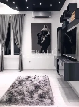 Modern living room with a sofa and a large TV. - image 4