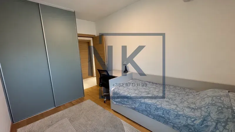 Small bedroom with a bed, wardrobe and a desk.