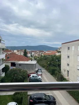 Pogled sa terase na naselje, zelenilo i brda u daljini. - image 12