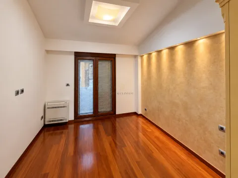 Empty room with wooden flooring, a decorative wall, and balcony doors. - image 16