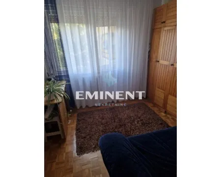 Manja spavaća soba sa krevetom, drvenim ormanom i prozorom sa zavesama. - image 9