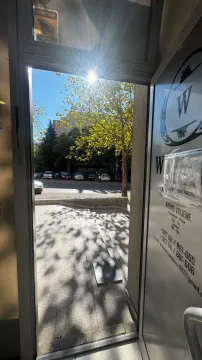View through the open entrance of the commercial space towards the street and parking lot. - image 4