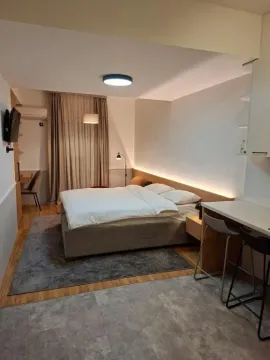Modern bedroom with a double bed, desk, and a breakfast bar. - image 8