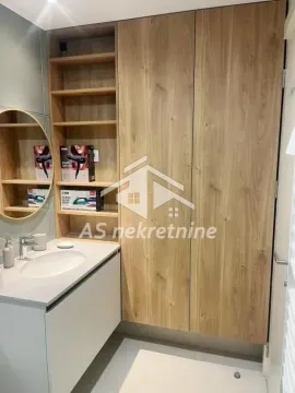 Modernly equipped bathroom with a washbasin, a large wooden cabinet, and a mirror. - image 3