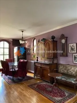 Spacious living room with classic wooden furniture and purple walls. - image 9