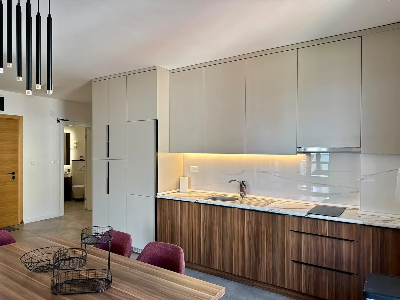 Modern kitchen with wooden elements and built-in lighting.