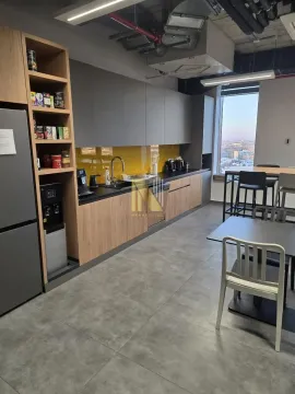 Modern and equipped kitchen with dining table and window view. - image 3