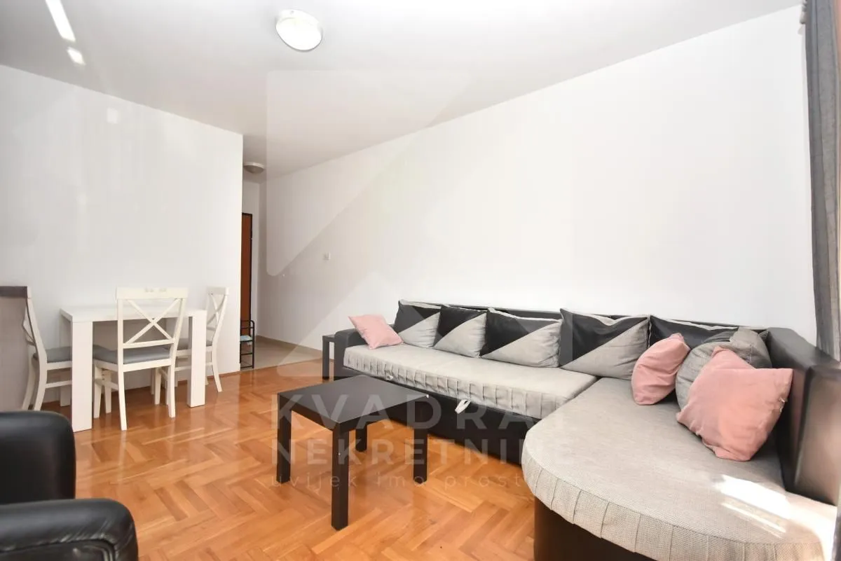 Living room with a sofa set, coffee table, and a dining table with chairs.