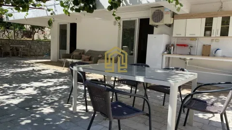Covered terrace with seating furniture and an outdoor kitchen in the yard. - image 18