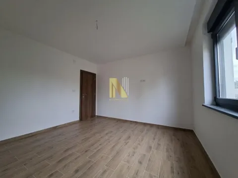 Prazna soba sa belim zidovima, drvenim podom i vratima. - image 7