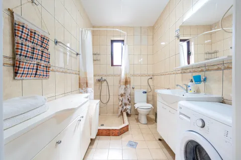 Bathroom equipped with sanitary ware, a shower cabin, and a washing machine. - image 6