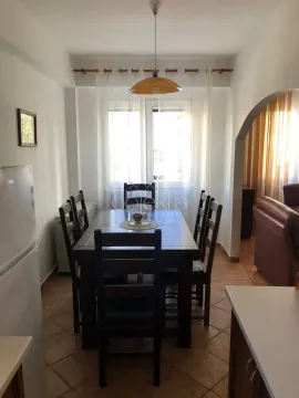 Dining area with a wooden table and chairs, connected to the kitchen. - image 9