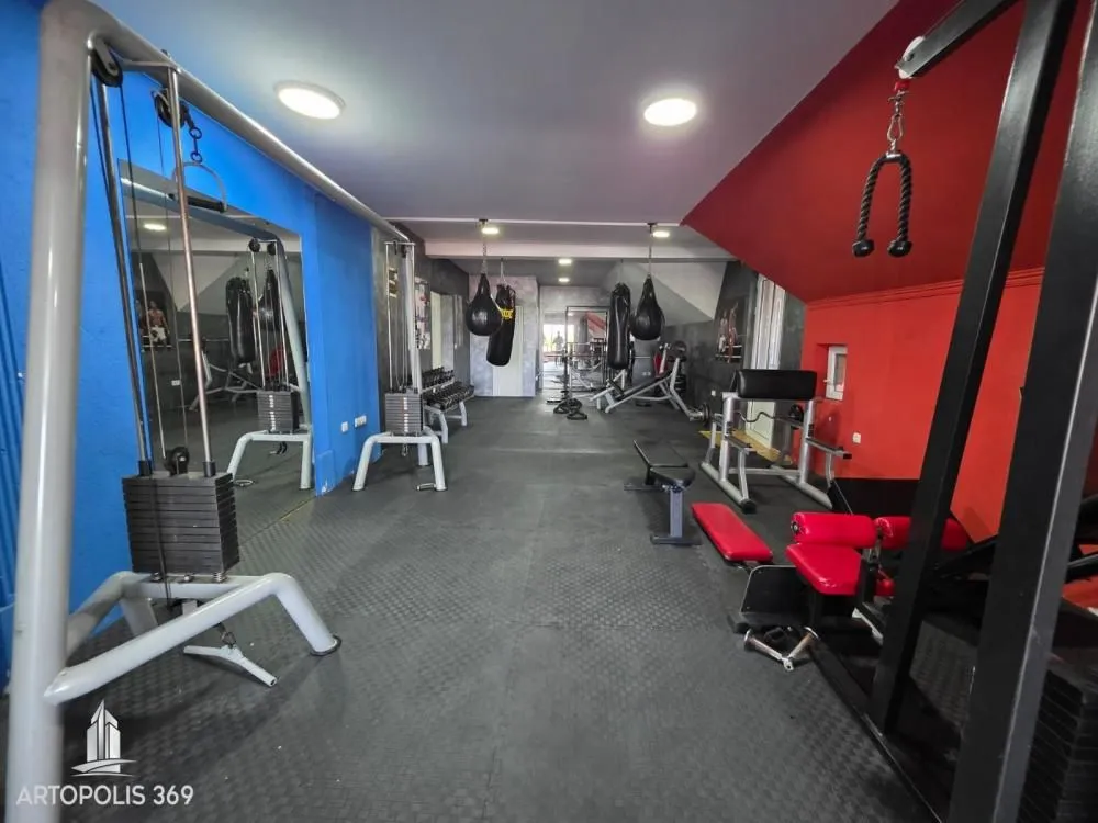 Room equipped with exercise machines and punching bags.