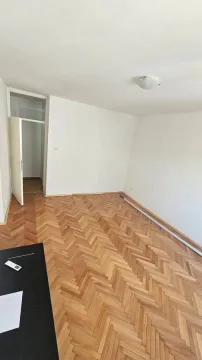 Prazna soba sa parketom i bijelim zidovima. - image 2