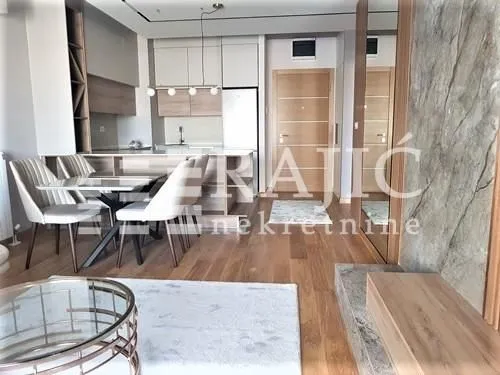 Modern living room with dining area and kitchen in the background.