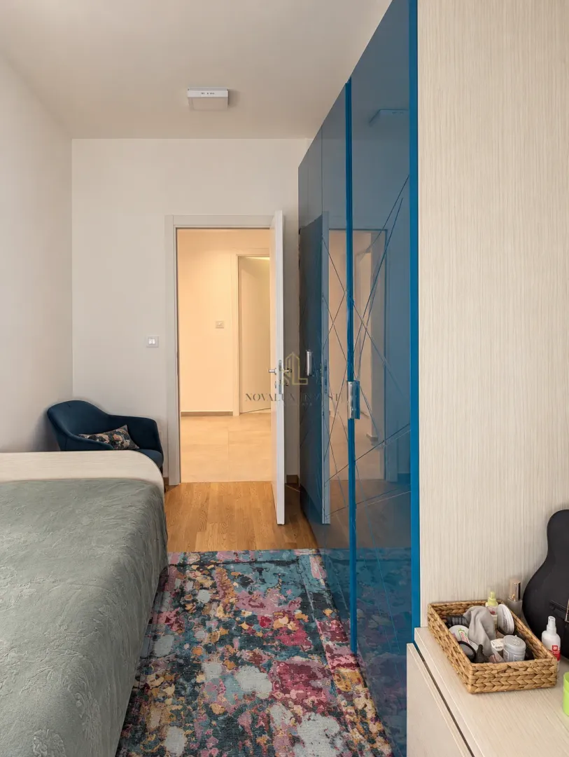 Bedroom with a bed, a large blue wardrobe, and a rug.