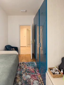 Bedroom with a bed, a large blue wardrobe, and a rug. - image 9